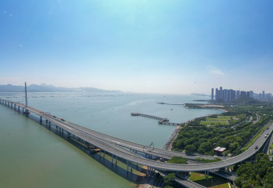 深圳灣大橋是繼羅湖、皇崗和沙頭角之后深圳第4條跨境通道，全長5545米，設南北兩個通航橋，主跨分別為210米和180米。大橋連接深圳蛇口與香港元朗，為中國公路干線網中唯一與香港連接的高速公路大橋，也是廣深沿江高速公路的咽喉。廣州與香港的距離因該橋建成通車縮短至100千米。大橋深圳側獨塔斜拉橋塔采用向香港側傾斜的斜塔，與香港側斜拉橋的橋塔向深圳側傾斜互相對應，寓意深港兩地手牽手走向一起。圖為深圳灣大橋。