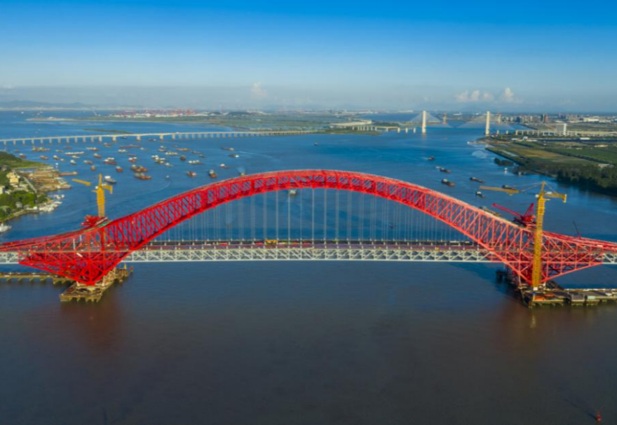 明珠灣大橋位于廣州市南沙區龍穴南水道之上，是粵港澳大灣區的重要連接通道。大橋工程全長約10.42公里，主線全長約9.1公里，主橋采用中承式六跨連續鋼桁拱橋，全長1016米，為同類型橋梁最大跨度。氣勢恢宏的明珠灣大橋綿延伸向遠方，將南沙多條核心主干道緊緊連在一起，構筑了明珠灣區內部核心交通環，是廣州面向粵港澳大灣區建設的交通樞紐工程和地標性建筑。圖為南沙明珠灣大橋。