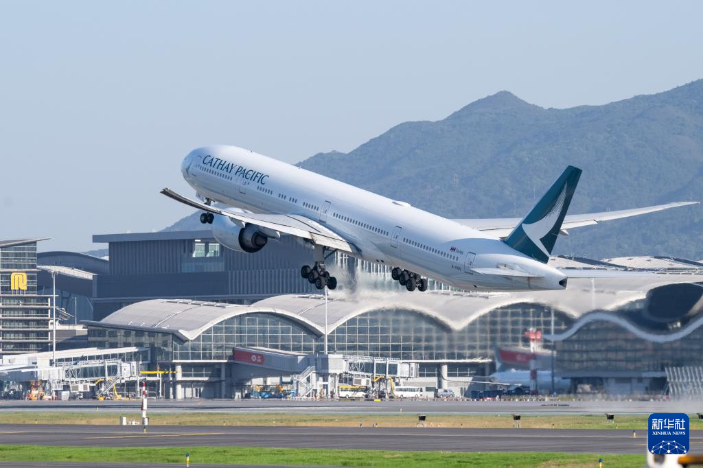 11月28日，香港國際機場三跑道系統(tǒng)正式啟用后，一架飛機從中跑道起飛。新華社記者 朱煒 攝