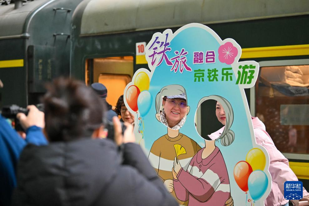 3月15日，在天津站站臺，銀發族游客在“京鐵樂游”號銀發旅游列車發車前拍照留念。新華社記者 孫凡越 攝