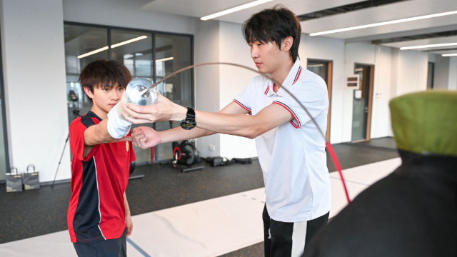 ↑圖為廣東現代五項運動協會教練員肖勇炫（右）糾正廣州市中黃港澳子弟學校港籍生張嗣濤擊劍技術細節（6月19日攝）。新華社記者肖恩楠攝
