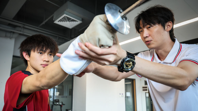 圖為廣東現代五項運動協會教練員肖勇炫（右）糾正廣州市中黃港澳子弟學校港籍生張嗣濤擊劍技術細節