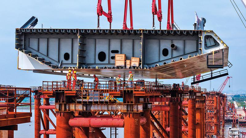 施工人員在位于廣州南沙區的萬龍大橋鋼梁支架上接收首節鋼箱梁(2025 年 4 月 29 日攝) 劉大偉攝 / 本刊 施工人員在位于廣州南沙區的萬龍大橋鋼梁支架上接收首節鋼箱梁(2025 年 4 月 29 日攝) 劉大偉攝 / 本刊