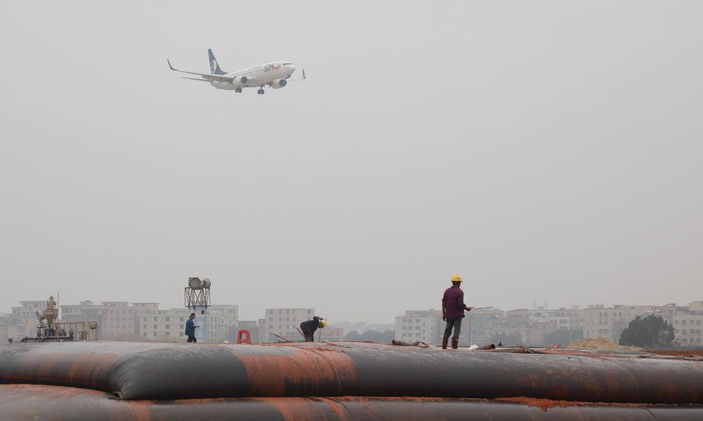 2025年1月23日,一架準備降落的飛機經過白云機場擴建工程施工現場。新華社記者 田建川 攝 2025年1月23日,一架準備降落的飛機經過白云機場擴建工程施工現場。新華社記者 田建川 攝