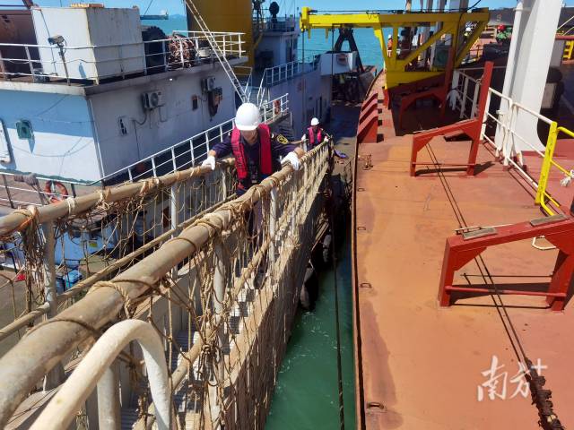 關員搭乘交通艇駛向一艘裝載著16.3萬噸進口鐵礦石的巨輪，對該輪實施登輪監管。