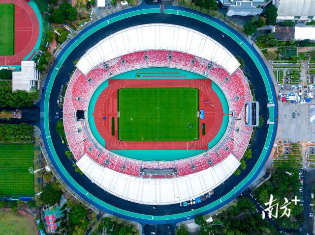 從空中俯瞰，體育中心的停車場上方，一塊塊光伏板有序排布，在陽光下泛著光。