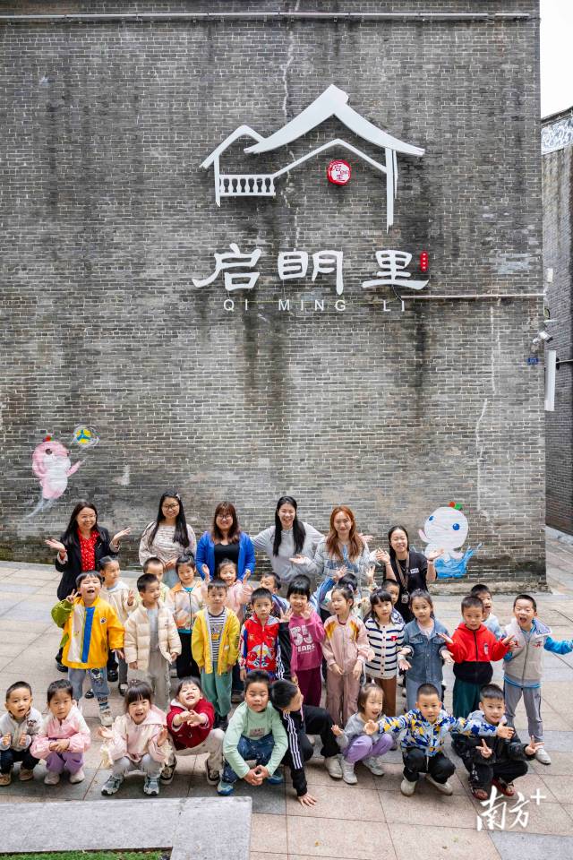 小朋友與吉祥物小海豚墻繪合影留念。