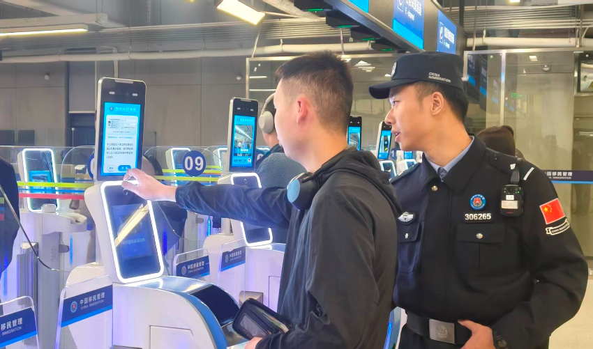 皇崗邊檢站民警指導(dǎo)首次經(jīng)智能快捷通道入境的香港旅客“刷臉”代替“刷證”體驗(yàn)。 通訊員 黃俊生 供圖